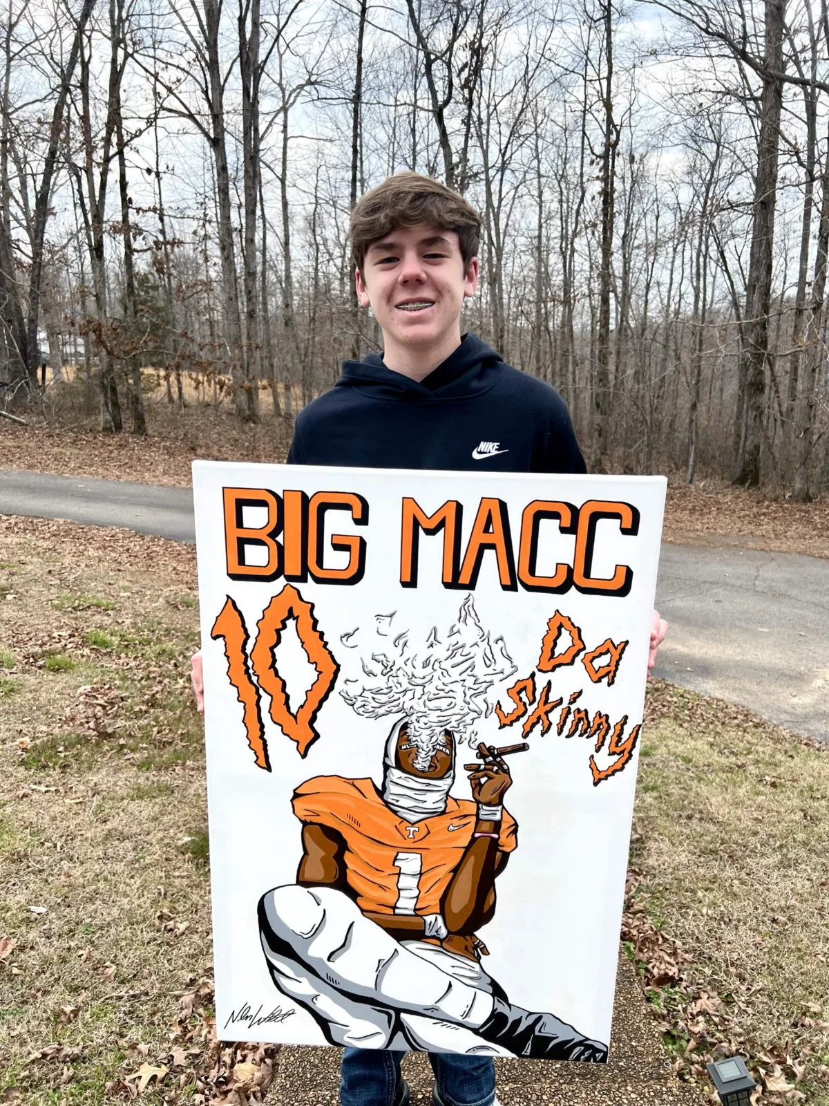 A custom football artwork held outdoors